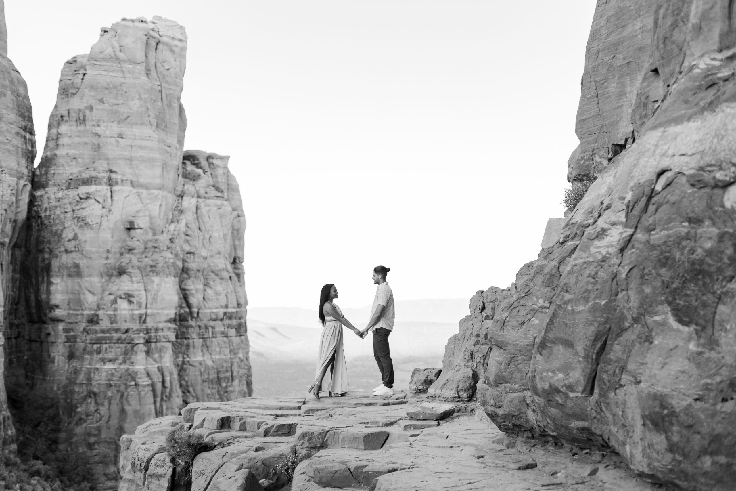 Photo of Lakin and Jasmyne at Sunrise:
"Lakin and Jasmyne stand together on top of Cathedral Rock in Sedona at sunrise, with the warm, golden light highlighting their joyful expressions and the stunning red rock formations in the background."