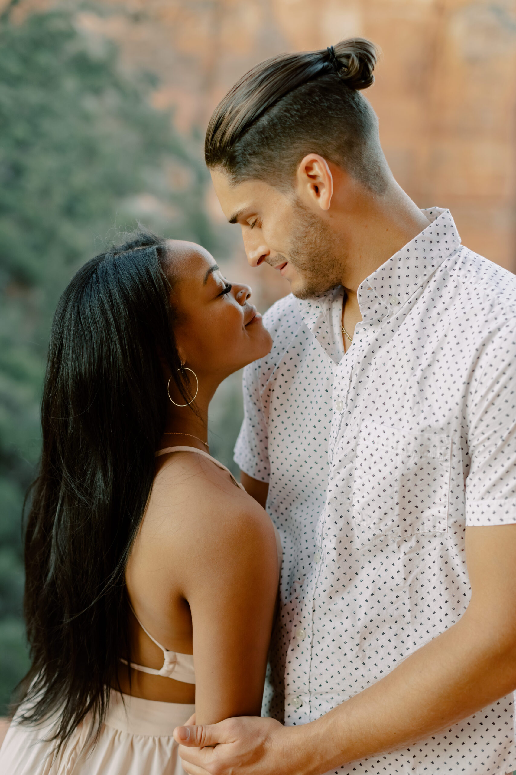 Photo of Lakin and Jasmyne at Sunrise:
"Lakin and Jasmyne stand together on top of Cathedral Rock in Sedona at sunrise, with the warm, golden light highlighting their joyful expressions and the stunning red rock formations in the background."