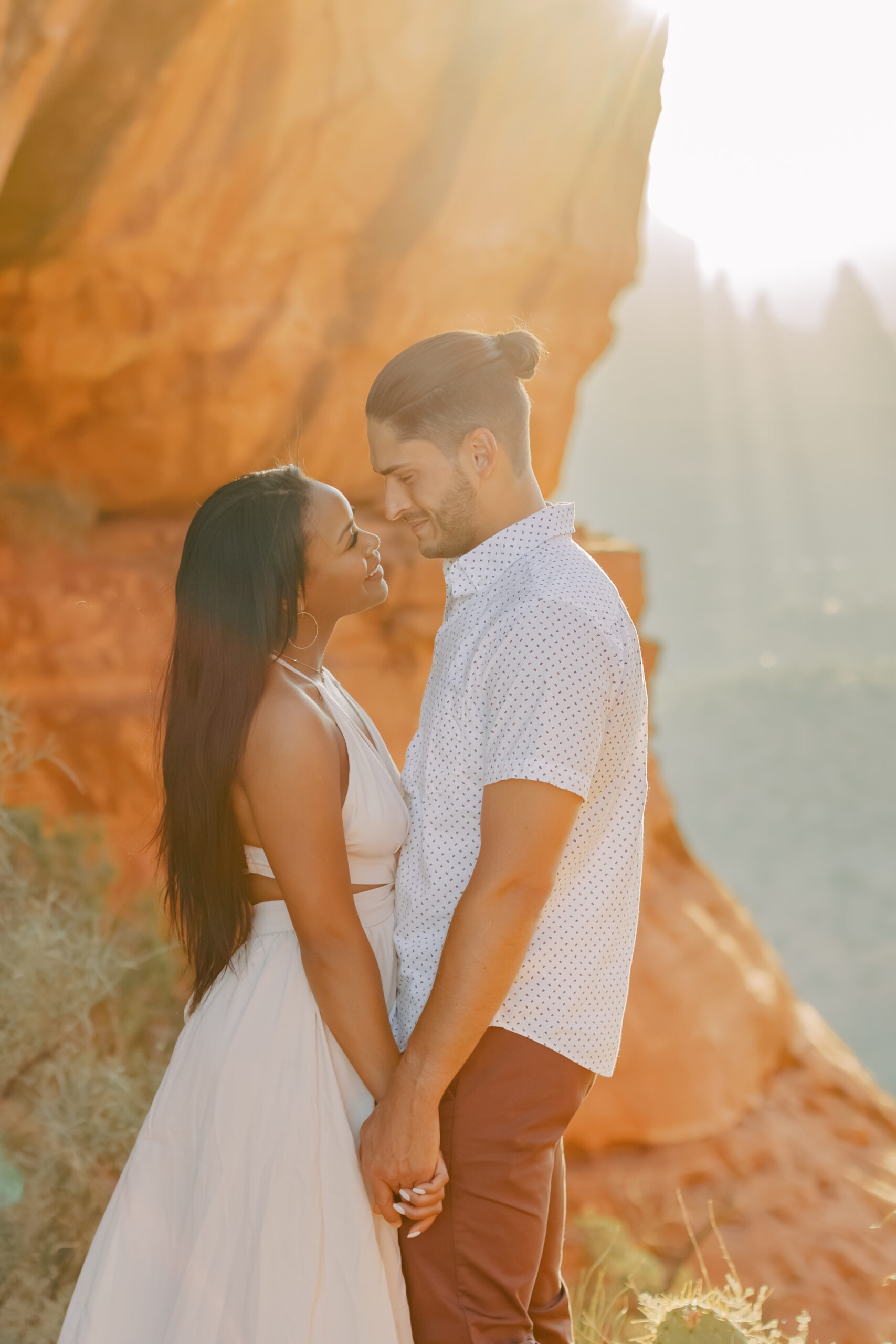 Photo of Lakin and Jasmyne at Sunrise:
"Lakin and Jasmyne stand together on top of Cathedral Rock in Sedona at sunrise, with the warm, golden light highlighting their joyful expressions and the stunning red rock formations in the background."