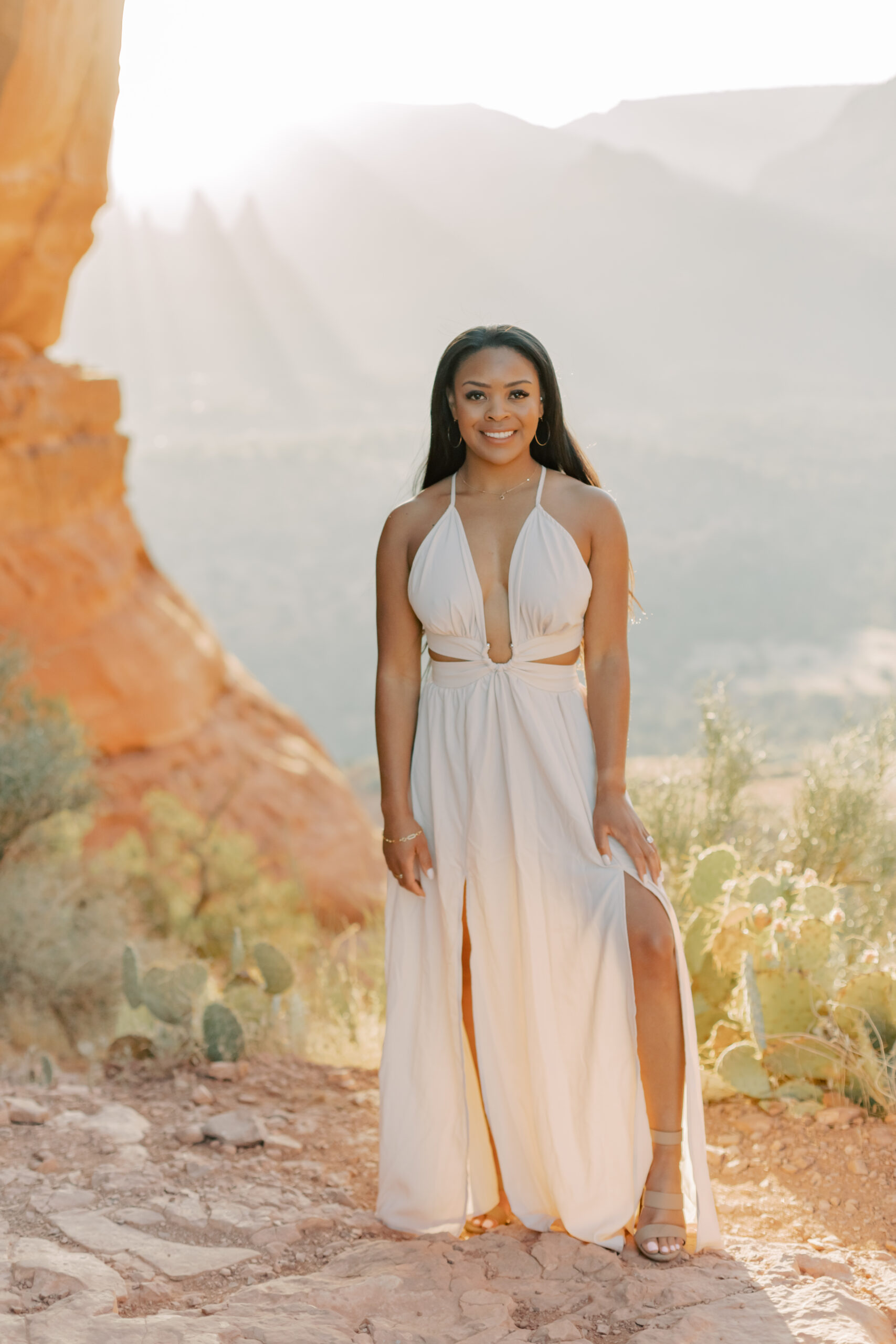 Single shot of Jasmyne against Sedona's backdrop
Jasmyne stands against the mountains with light from sunrise interwoven between different peaks. 