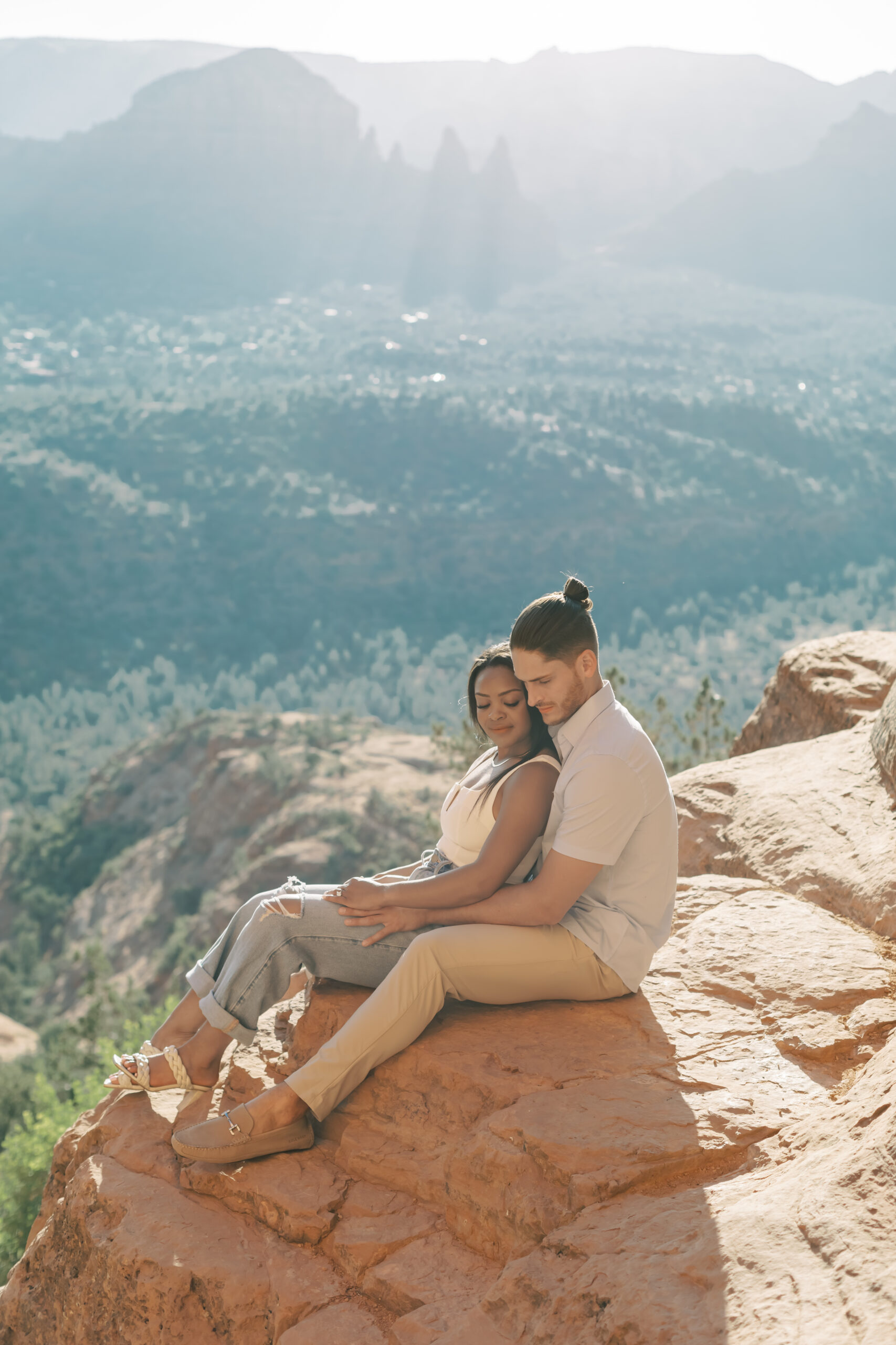 Photo of Lakin and Jasmyne at Sunrise:
"Lakin and Jasmyne stand together on top of Cathedral Rock in Sedona at sunrise, with the warm, golden light highlighting their joyful expressions and the stunning red rock formations in the background."