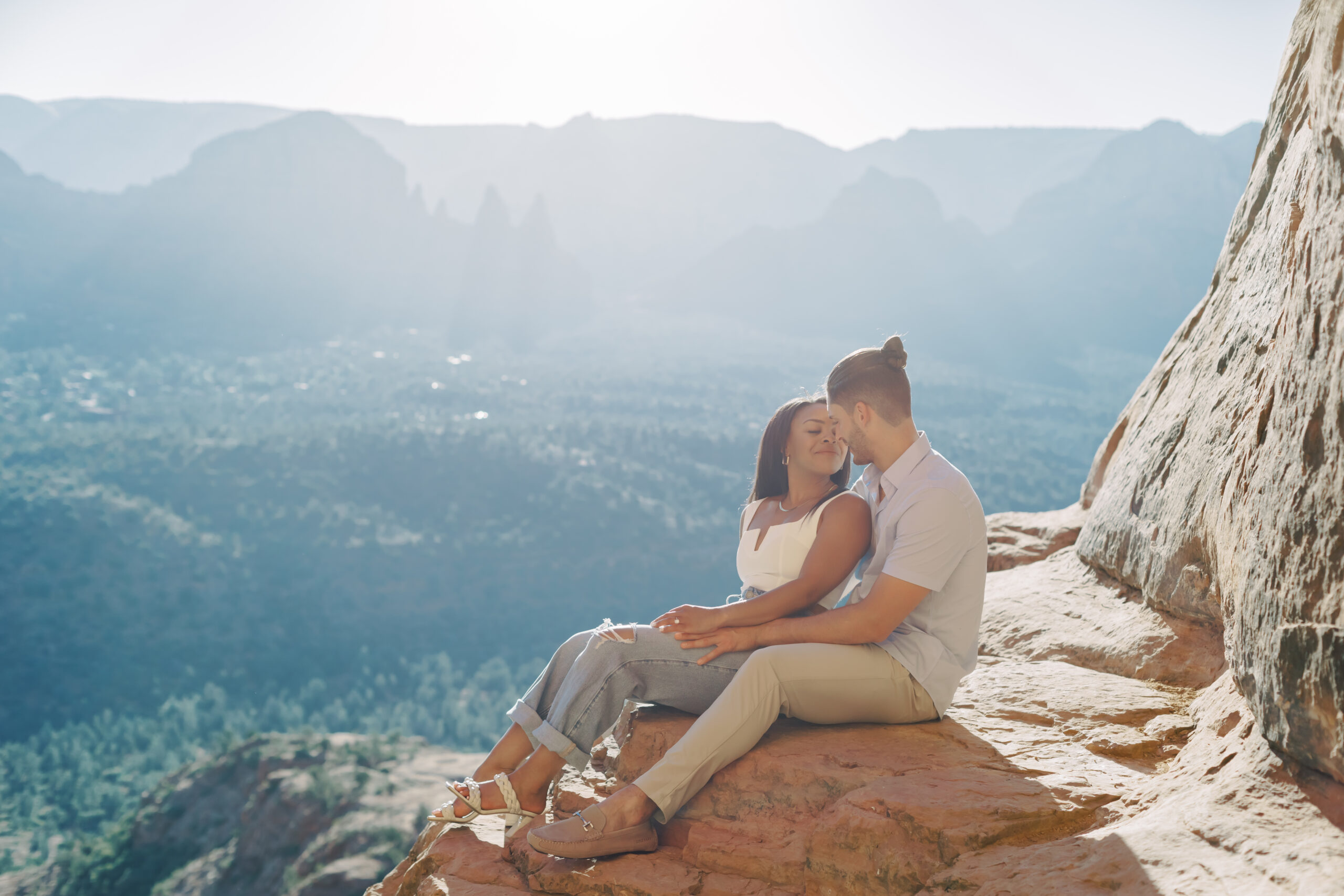 Photo of Lakin and Jasmyne at Sunrise:
"Lakin and Jasmyne stand together on top of Cathedral Rock in Sedona at sunrise, with the warm, golden light highlighting their joyful expressions and the stunning red rock formations in the background."