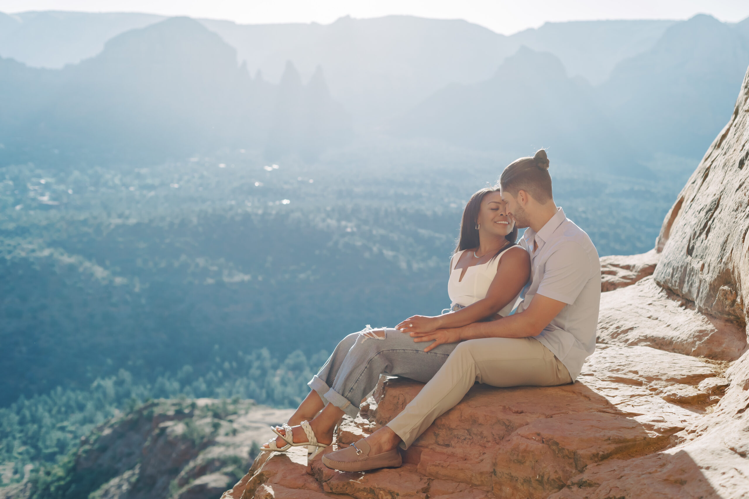 Photo of Lakin and Jasmyne at Sunrise:
"Lakin and Jasmyne stand together on top of Cathedral Rock in Sedona at sunrise, with the warm, golden light highlighting their joyful expressions and the stunning red rock formations in the background."