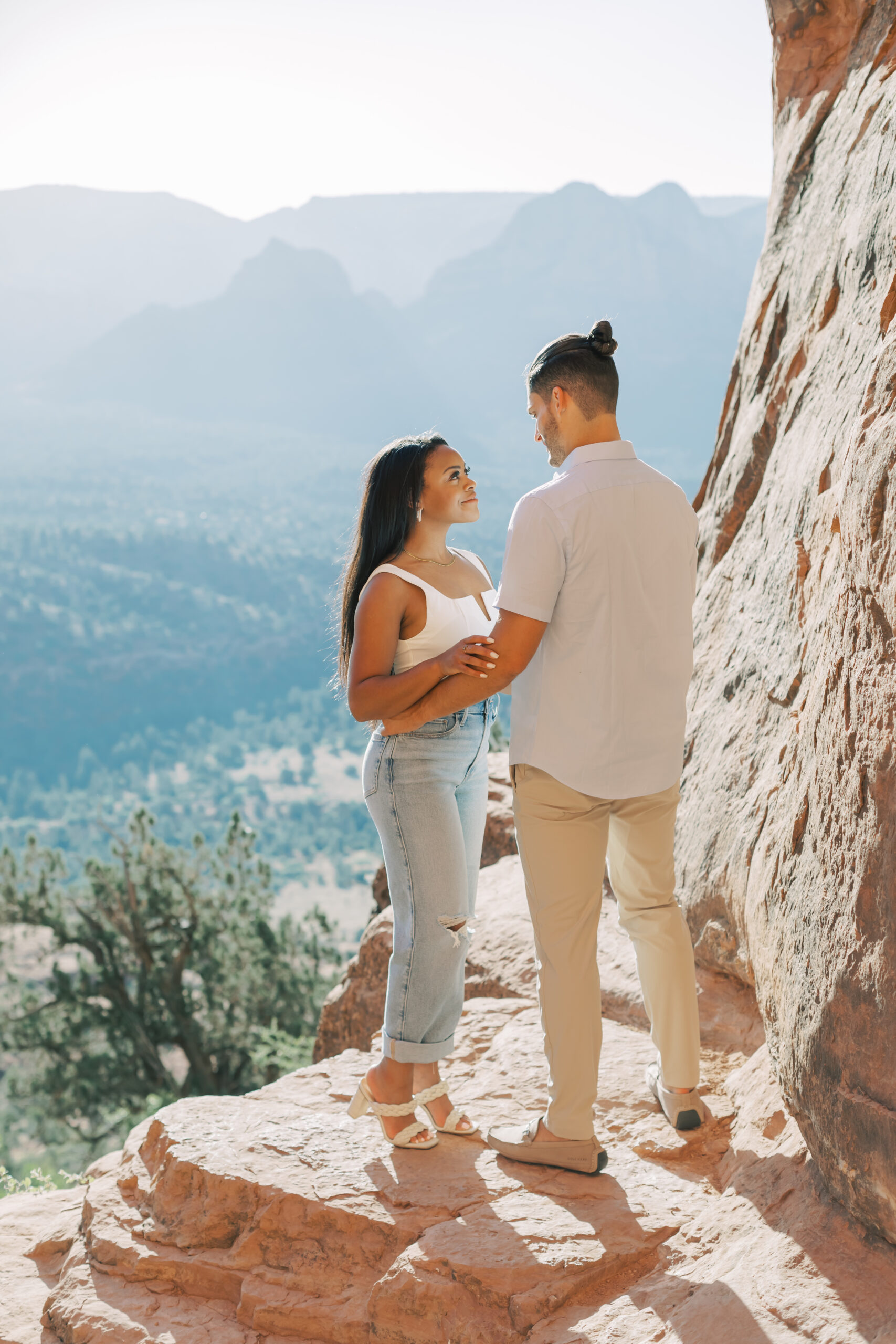 Photo of Lakin and Jasmyne at Sunrise:
"Lakin and Jasmyne stand together on top of Cathedral Rock in Sedona at sunrise, with the warm, golden light highlighting their joyful expressions and the stunning red rock formations in the background."