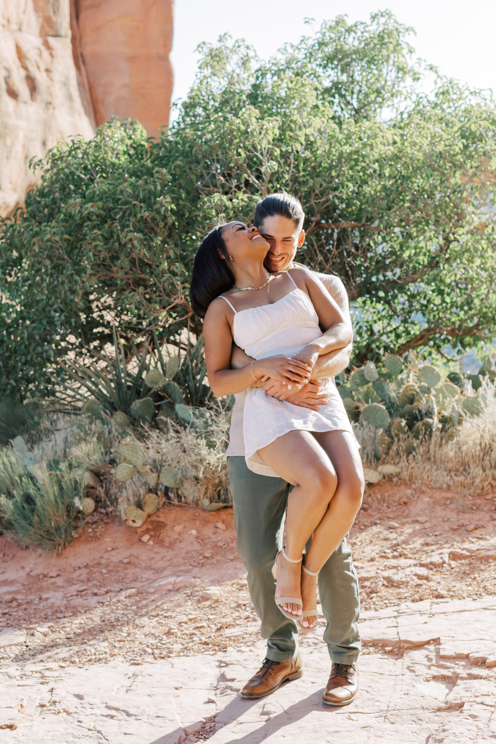 Photo of Lakin and Jasmyne at Sunrise:
"Lakin and Jasmyne stand together on top of Cathedral Rock in Sedona at sunrise, with the warm, golden light highlighting their joyful expressions and the stunning red rock formations in the background."