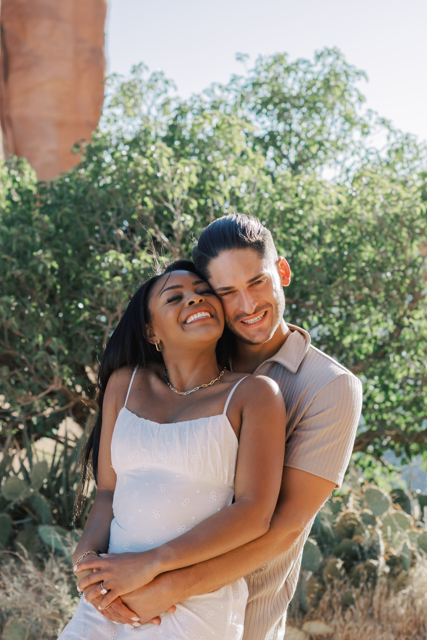 Photo of Lakin and Jasmyne Laughing:
"Lakin and Jasmyne share a laugh while sitting on a rock ledge, their joy and connection evident, with the early morning light casting a soft glow over the scene."