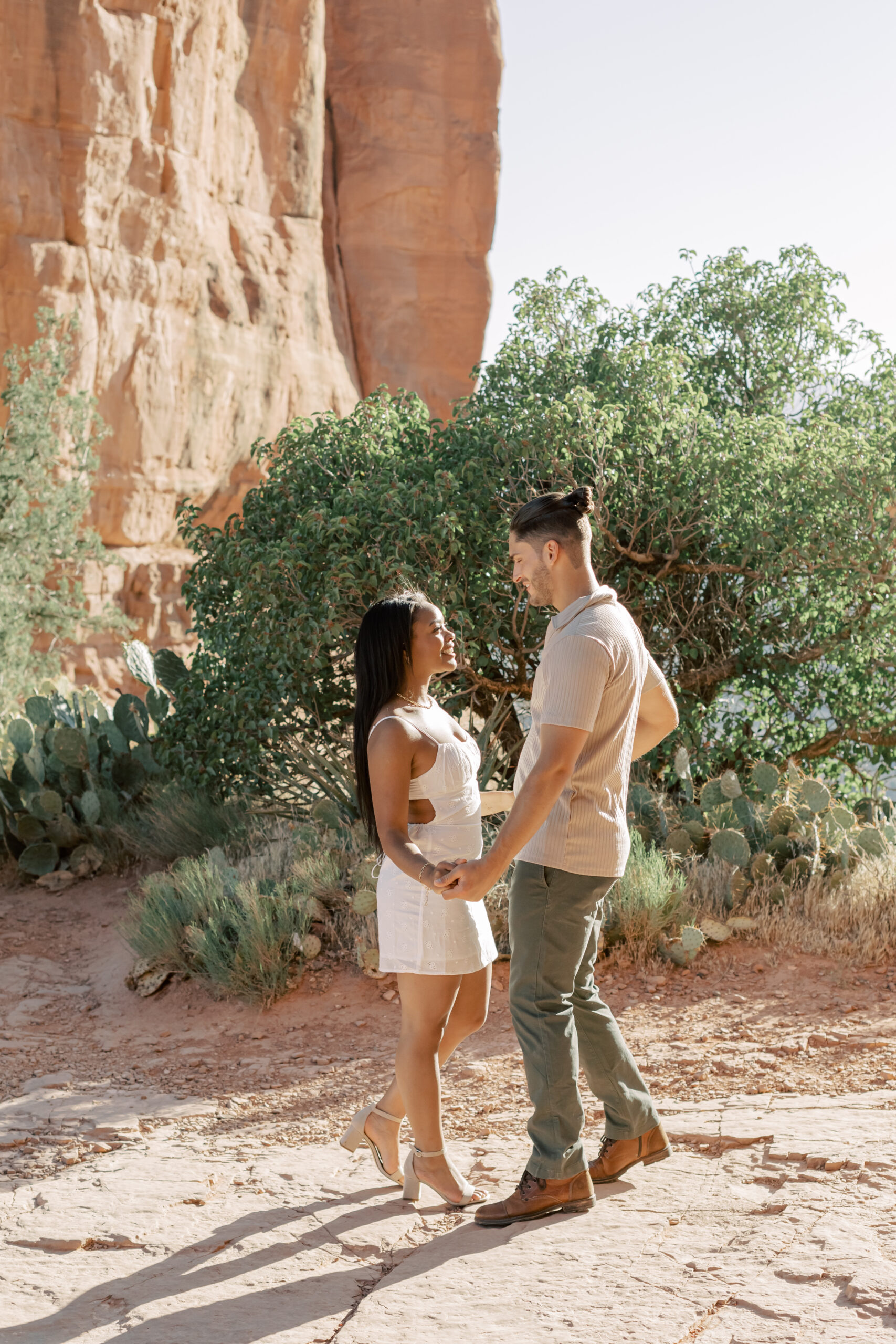 Photo of Lakin and Jasmyne at Sunrise:
"Lakin and Jasmyne stand together on top of Cathedral Rock in Sedona at sunrise, with the warm, golden light highlighting their joyful expressions and the stunning red rock formations in the background."