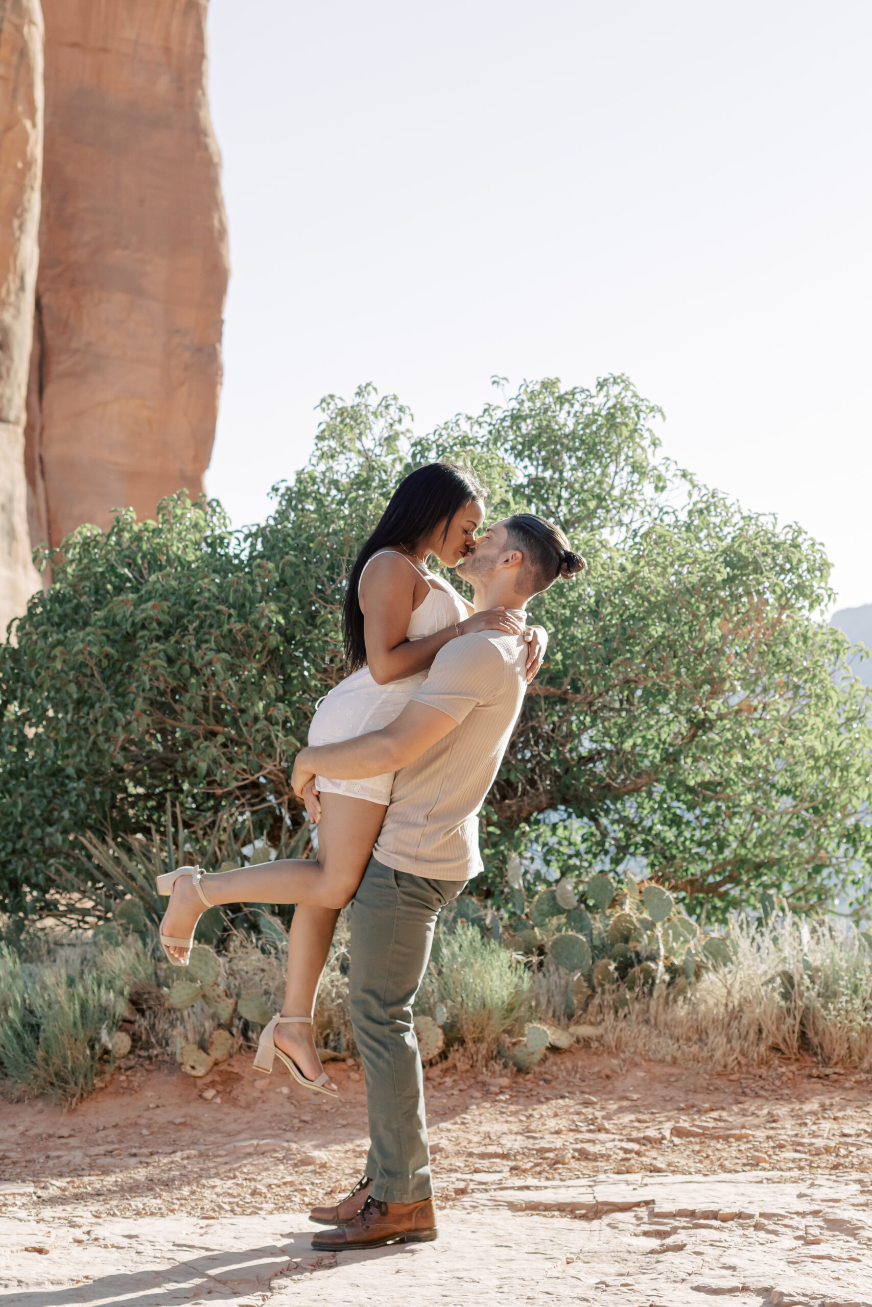 Photo of Lakin and Jasmyne at Sunrise:
"Lakin and Jasmyne stand together on top of Cathedral Rock in Sedona at sunrise, with the warm, golden light highlighting their joyful expressions and the stunning red rock formations in the background."