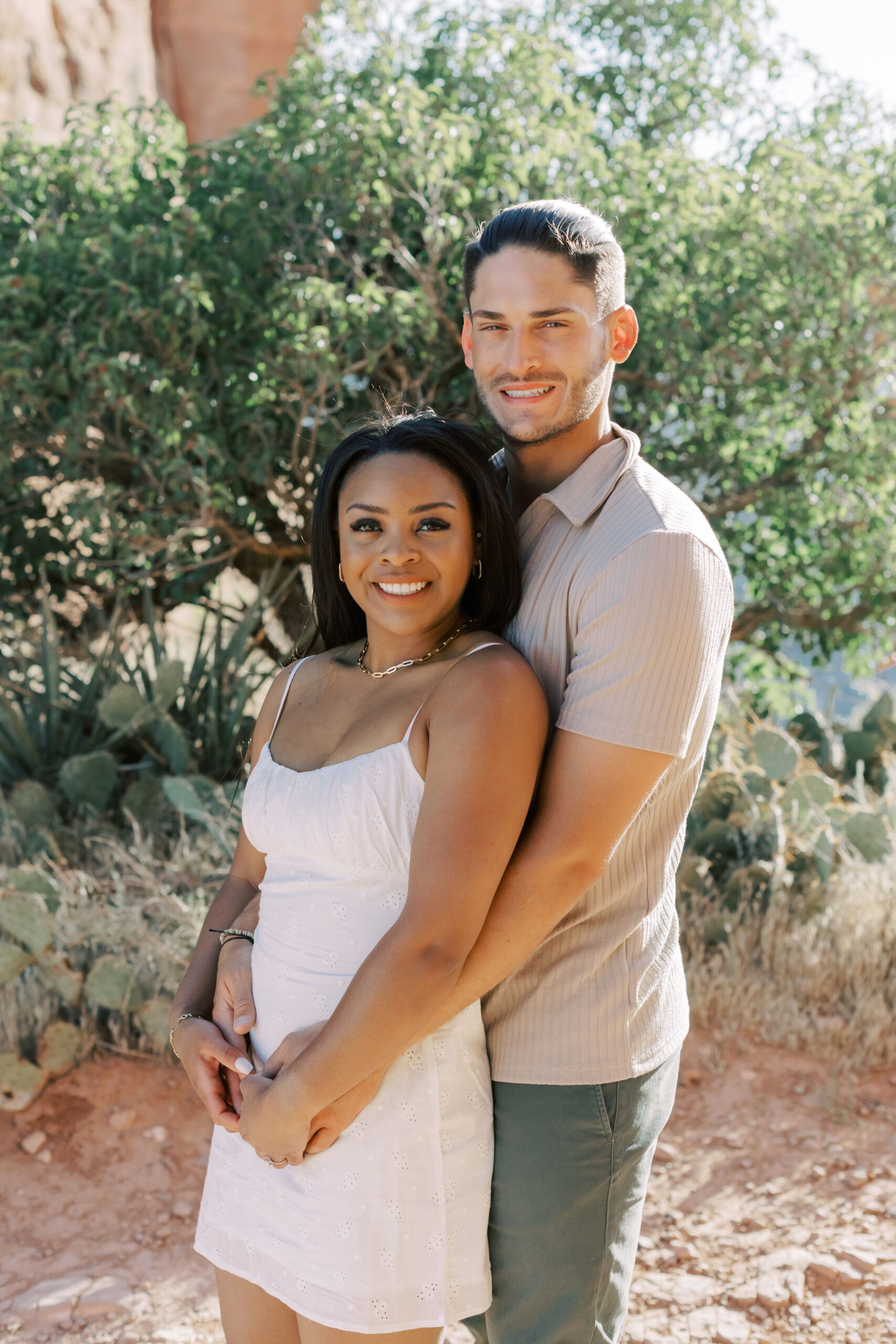 Photo of Lakin and Jasmyne at Sunrise:
"Lakin and Jasmyne stand together on top of Cathedral Rock in Sedona at sunrise, with the warm, golden light highlighting their joyful expressions and the stunning red rock formations in the background."