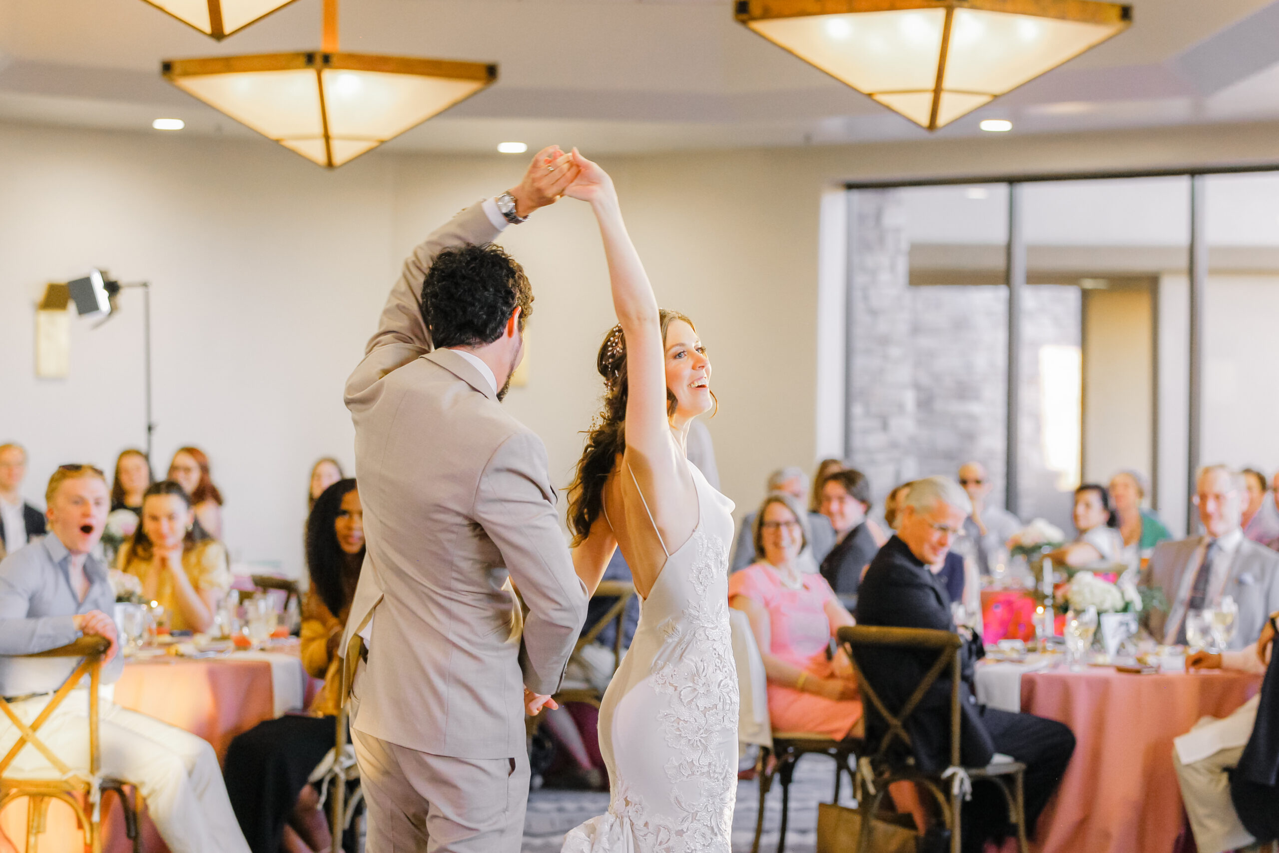 Bride and groom sharing their first dance at their wedding reception at Troon North in Scottsdale, dancing under twinkling lights with desert scenery in the background.